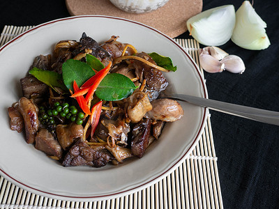 炸猪内脏的名字是 Phad cha 泰国菜，配料是猪肉馅辣椒 Krachai 大蒜洋葱和 Kaffir 石灰叶，杯子里的米饭，背景颜色黑色