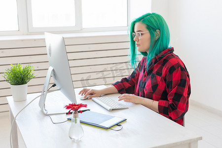 笔记本电脑插画摄影照片_设计师、插画家、艺术家和人物概念 — 工作时使用笔记本电脑和图形平板电脑的当代绿发年轻女性肖像