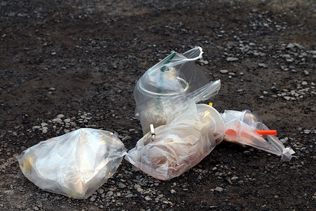 堆放垃圾垃圾饮料玻璃和塑料袋，地板上脏的水杯，塑料垃圾