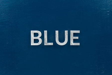蓝色这个词在经典的蓝色彩绘板背景上铺着银色金属字母