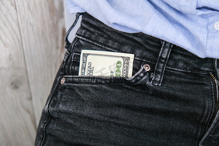 放进口袋摄影照片_把钞票放进口袋里的女商人的手合上。