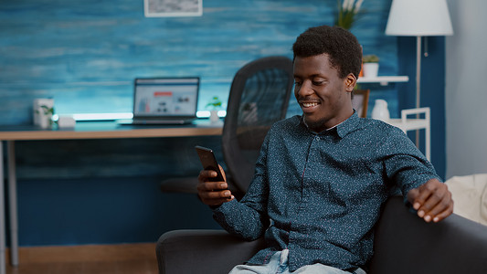 正宗的非洲裔美国人在虚拟通信视频通话中使用他的电话与亲戚或同事交谈