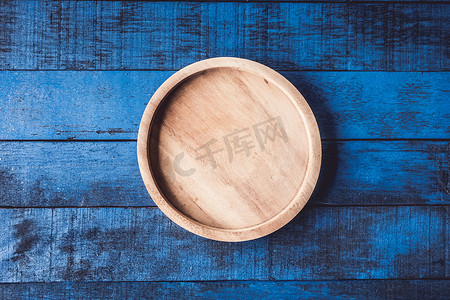 空木盘摄影照片_在 bule 木桌背景上的木盘的顶部视图。