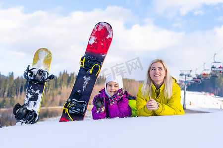带着滑雪板的母女正在雪地里玩耍