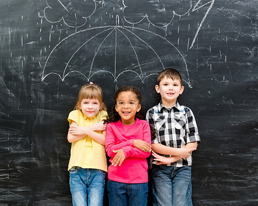 三个孩子站在拉着的伞下