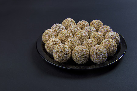 黑色背景的黑色盘子中的苋菜 ladoo 或 Rajgira laddu 或 Cholai ke laddu。