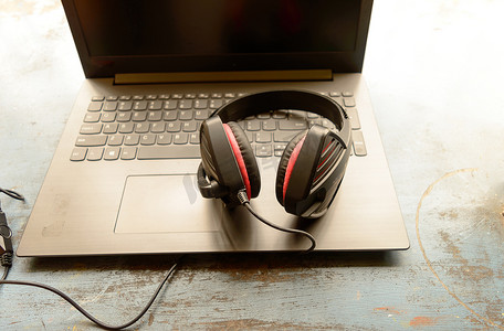 便携式耳罩式双耳 USB 耳机，带麦克风降噪和超声波音量调节耳机，适用于计算机，Skype 在早晨阳光下放在笔记本电脑上。