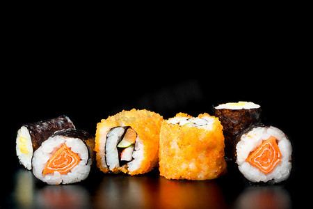 日本料理水彩摄影照片_黑色背景的寿司卷，日本料理。