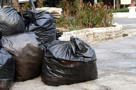 废塑料，地面公共公园堆放大量垃圾黑袋，许多垃圾黑垃圾塑料袋堆