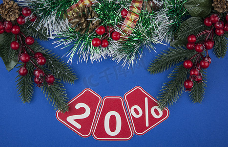 大销售额 20%，20% 的圣诞节花环在深蓝色背景、顶视图、复制空间、平面布局。