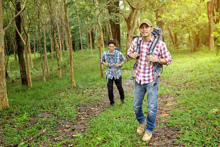 两个英俊的男人在假期期间在树林里游览。