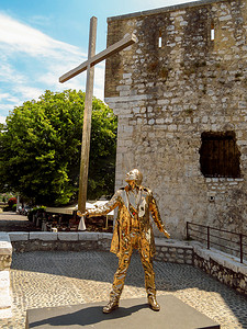 Saint Paul de Vence - 一个有十字架的人的金色雕塑