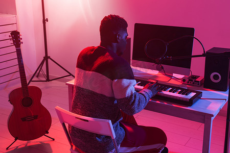 电脑制作摄影照片_音乐家和制作音乐概念-在录音室工作的非裔美国男性声音制作人。