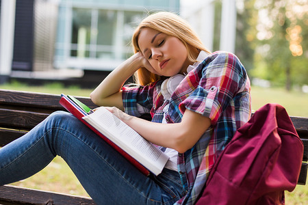 疲惫的女学生在学习时睡着了