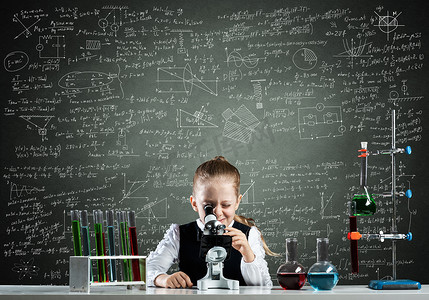 看通过显微镜的小女孩科学家