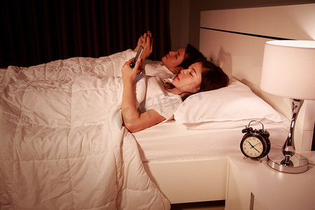 晚上在床上玩手机的情侣