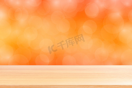模糊散景柔和橙色渐变背景上的空木桌地板，橙色散景彩色浅色上空的木板，用于横幅广告产品的彩色散景灯渐变柔和