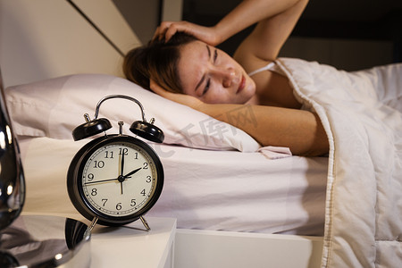 卧室摄影照片_时钟显示 2 点钟和女人在床上失眠