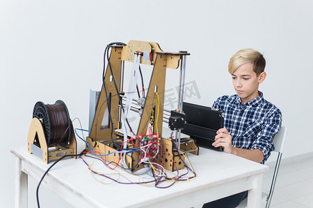 教育、儿童、技术概念-青少年男孩正在 3d 打印机上打印。