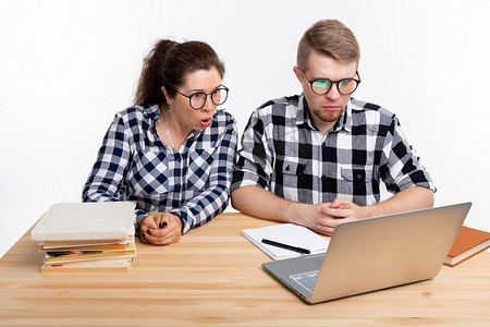 教育、学生、人的概念 — 几个戴眼镜的青少年在看笔记本电脑时害怕什么