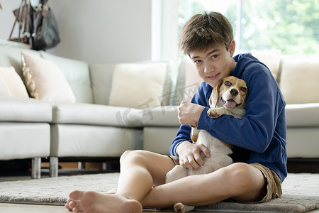 拥抱孩子摄影照片_孩子在家和他的宠物狗玩耍