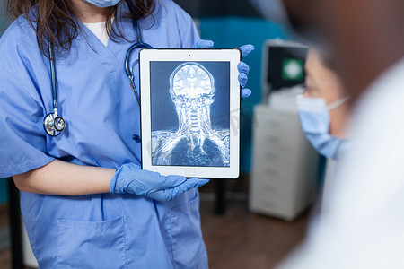 治疗师女助理拿着带有放射线照相的平板电脑的特写