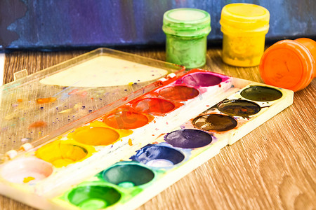 水粉展板摄影照片_水彩颜料，旧木桌上的刷子，水彩颜料，水粉画，刷子