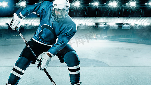 冰球运动员戴着头盔和手套在体育场上拿着棍子。