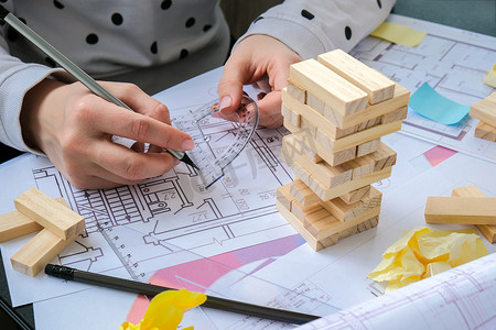 建筑师设计师室内创意工作手在房子的办公桌建筑计划上玩木块游戏，调色板。
