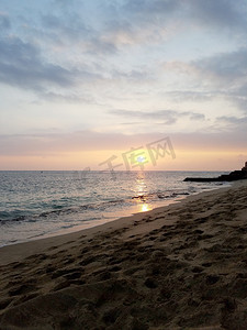 马卡雷海滩公园 (Makalei Beach Park) 的海浪拍打着海岸，欣赏威基基水域的日落美景