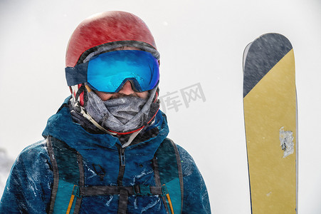 滑雪护目镜摄影照片_一个人的滑雪护目镜特写肖像有雪山反射的。