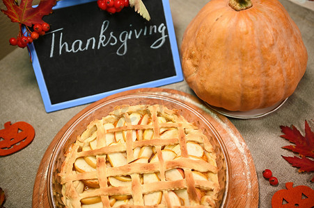 顶视图黑板上写着感恩节，甜甜的自制经典美国南瓜苹果派，外皮酥脆