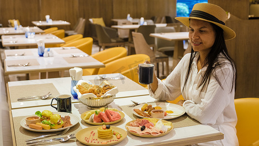 自助早餐摄影照片_在豪华酒店享用自助早餐的亚洲女性