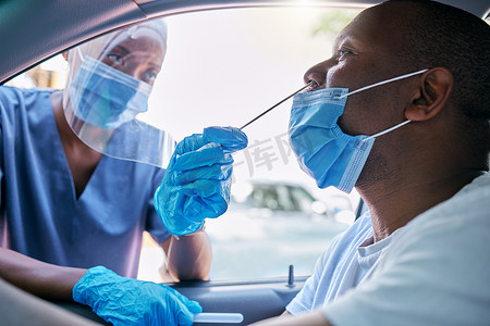 医生或护士在汽车餐厅对坐在车里的男子进行新冠病毒或日冕病毒测试。
