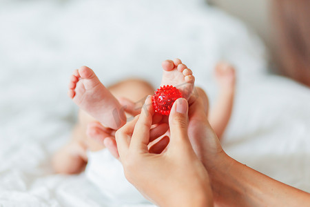 婴儿按摩小手摄影照片_母亲握住新生婴儿的脚。