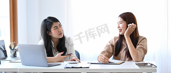 亚洲女商人分享想法或创业计划的其他同事。