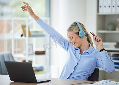 互联网笔记本电脑上的女商人，有趣的职业女孩在办公室跳舞，快乐的员工耳机在办公室。