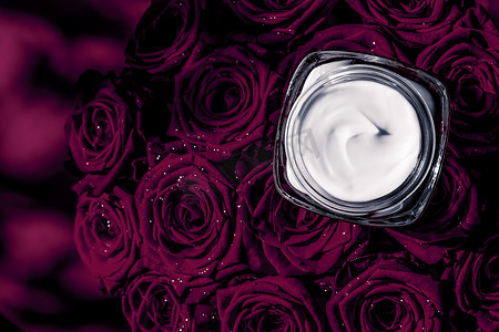 面霜皮肤保湿霜和深紫色花朵，以花卉背景为美容品牌假日平面设计的豪华护肤化妆品
