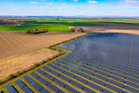 模块摄影照片_德国农村农田旁边有许多光伏板的太阳能公园的鸟瞰图