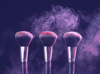 在 peri color 2022 背景上带有紫色粉末爆炸的化妆刷。