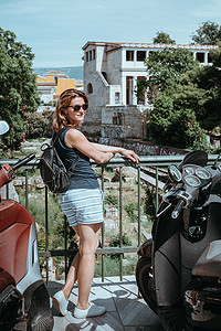 欧洲小镇摄影照片_美丽的女孩走在希腊首都雅典的一个古老的欧洲小镇的街道上。