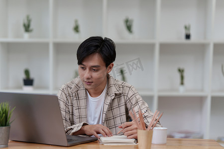 平面设计师在笔记本上绘图并在家里使用笔记本电脑。