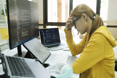年轻女子因工作编码和编程软件的压力而捂住脸。