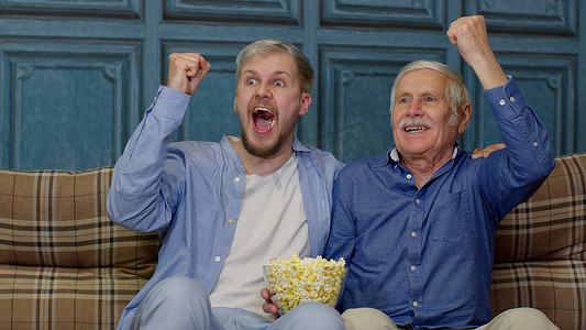 老祖父和年轻人在电视上看足球比赛，男性世代家庭