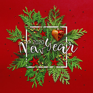 圣诞节背景与崖柏树枝和文字“新年2020”在白色方形框架中。