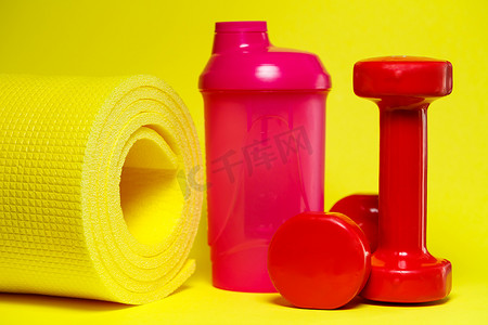 红色哑铃、粉色摇床、黄色垫子、彩色背景、体育、能量饮料、健身器材