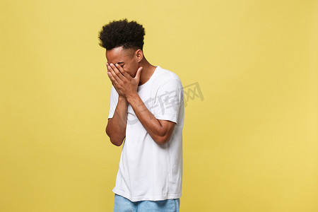 黄黑色背景摄影照片_特写肖像男子与悲伤的表情，孤立在黄墙背景上。