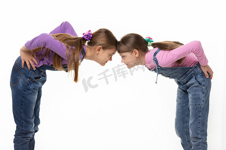 两个女孩争吵摄影照片_两个女孩额头靠在一起站着吵架