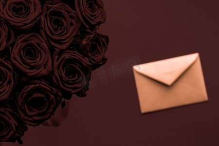 信封书信摄影照片_情人节送情书和鲜花，奢华的玫瑰花束和巧克力背景的卡片，适合浪漫的假日设计