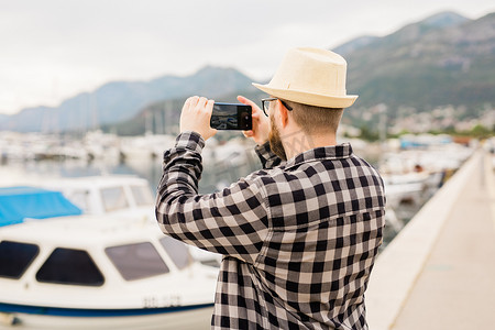手机夏季夏季摄影照片_旅行者在阳光明媚的日子里为豪华游艇拍照 — 旅行和夏季概念